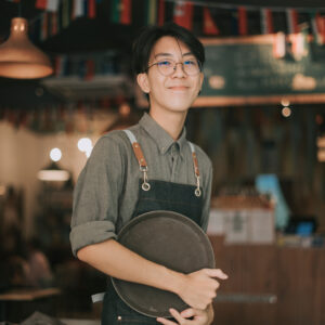 a smiling boy working in a cafe