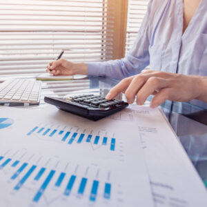 employee working on a spreadsheet using a calculator