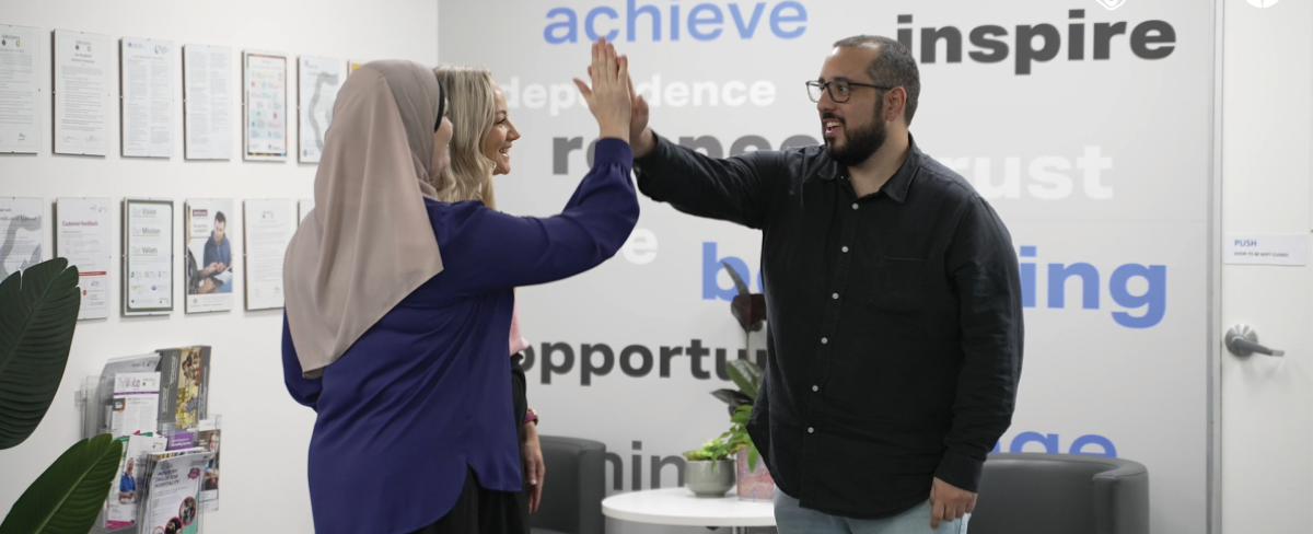 Employment consultant high fiving a participant in an office setting